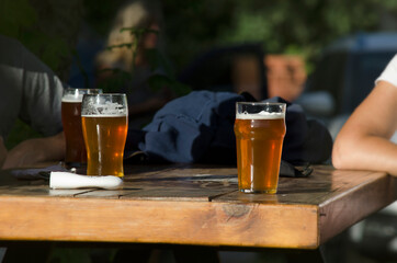 friends drinking pint of beer over wooden table