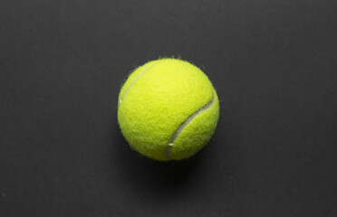 Yellow tennis ball over a black background