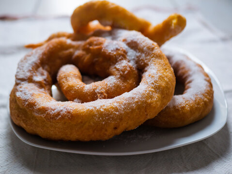 Woman frying vegan cattas sweet fritters, Sardinian Carnival cakes