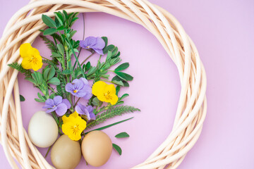 Bouquet of lilac and yellow flowers, easter eggs on a pink bright background with place for text