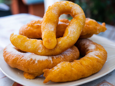 Woman frying vegan cattas sweet fritters, Sardinian Carnival cakes