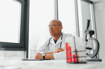 Naklejka na ściany i meble African American man male hospital doctor in white coat with stethoscope
