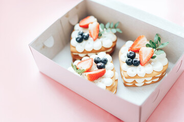 Delicious sweet puff snack with berries on top in a box. A sweet snack for any holiday. Holiday gift.