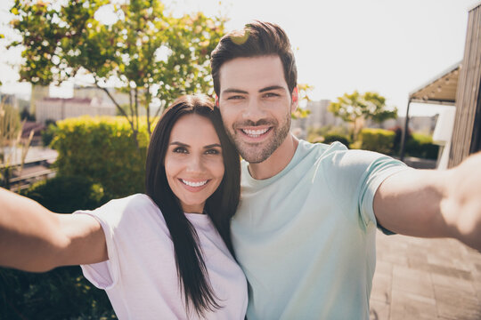 Photo of lovers couple take selfie look camera toothy shiny smile wear casual clothes in garden park outdoors