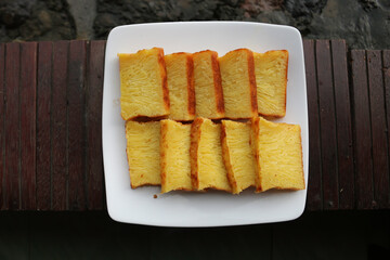 Bika Ambon, Indonesian cake with square slices in white plate. Yellow cake from Medan, Indonesia.