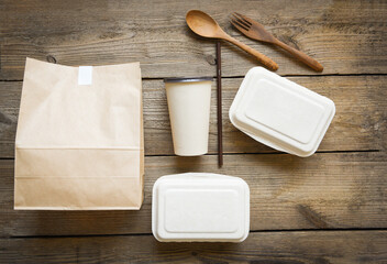 Service food order online delivery food box take away boxes, Disposable eco friendly packaging containers with paper cup and craft paper food on wooden table at home.