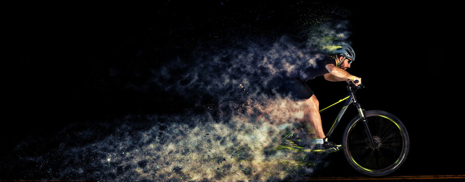 Man racing cyclist in motion . Cyclist in studio with creative effects. Scattering effect. Creative sport concept.