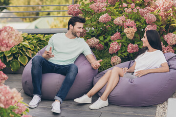 Photo of flirty romantic couple guy lady sit beanbag have conversation wear casual clothes park outside - Powered by Adobe