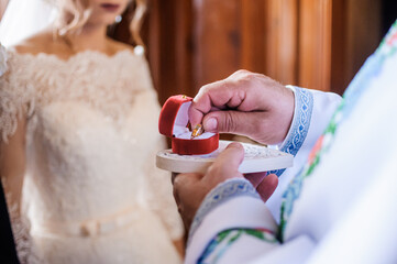 Wedding gold rings in the hands of the priest
