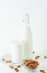 A glass with almond milk and the bowl with almonds