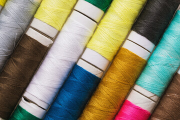 Texture from spools with multi-colored threads, top view, close-up