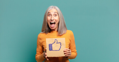 gray hair pretty woman holding a social media like banner