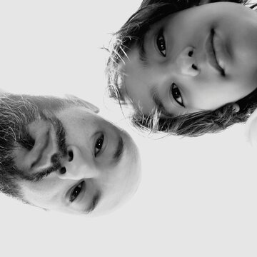 Low Angle Portrait Of Father With Son Against White Background