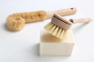 Cleaning brushes and soap bar for dish washing on white background, closeup