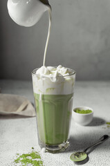 prepared matcha tea in a clear glass. a delicious drink made from Japanese green tea powder. vertical position