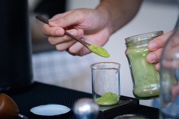 Barista Brew japanese matcha green tea in a bottol and pour in to a glass with equipment tool around on the table bar 