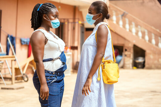 image of african women in face mask, black ladies having conversation-outdoor protection concept
