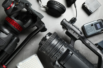 Flat lay composition with camera and video production equipment on grey stone background