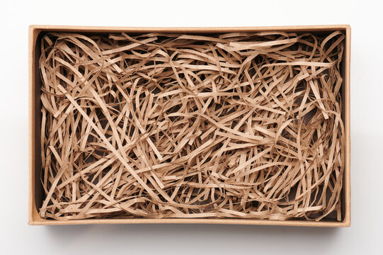Open brown box with shredded paper