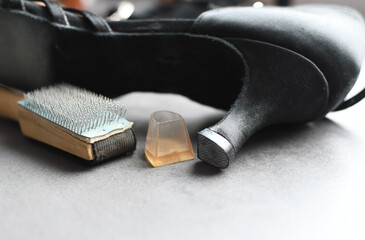 Wooden shoebrush next to ballroom dancing shoes. Use a brush to loosen the sole of the dance shoe...