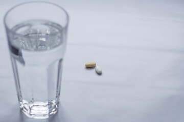 Vitamins are a healthy lifestyle. Tablets for improving the body. Natural organic supplements. Better health. A glass of water at the beginning of the day. Sports nutrition.