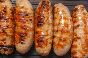 Sausages in frying pan. Cooking breakfast, fast food.
