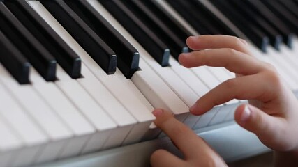 The child plays the piano theme. Close-up of fingers of a boy learning playing the piano. Creativity in children. Playing the piano. Selective focus, shallow depth of field