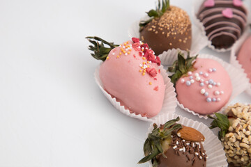 Assorted strawberries in chocolate, sweet dessert, free space for your text, sprinkled with nuts, top view, isolated background.