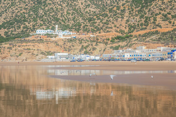 Whitewash buildings and seagulls at low tide at the seaside fishing village of Tafedna in the...