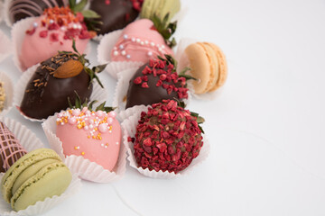 Assorted strawberries in chocolate with macaron, sweet dessert, free space for your text, sprinkled with nuts, top view, isolated background.