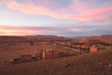 Fototapeta na wymiar A sunset or sunrise view with pink sky of old town Ait Benhaddou, Morocco a historic fortified village, noted for its ancient clay earthen architecture.