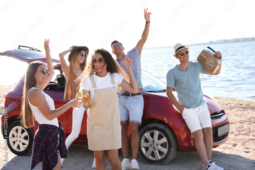 Sticker Happy friends having fun near car on beach. Summer trip