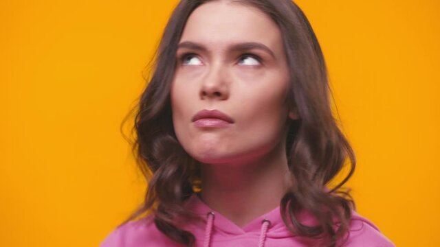 displeased young woman rolling eyes isolated on yellow