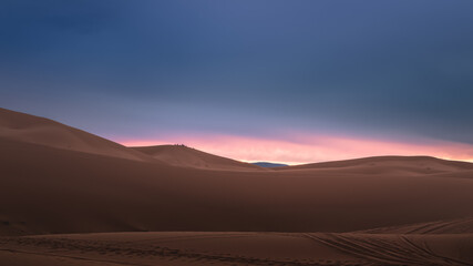 Fototapeta na wymiar A moody sunrise or sunset landscape view of the desert sand dunes of Erg Chebbi near the village of Merzouga, Morocco.