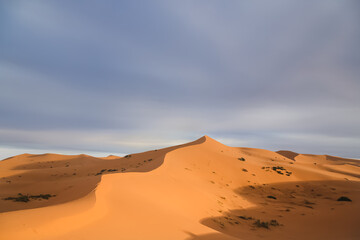 Fototapeta na wymiar Dramatic shadow and light over the desert sand dune landscape of Erg Chebbi near the village of Merzouga in southeastern Morocco.