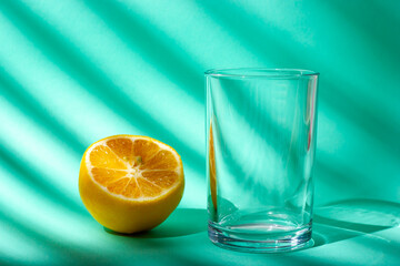Glass water cup and lemon. Sunlight from the window.