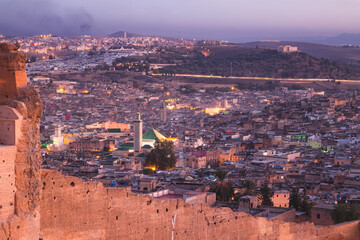 Night cityscape skyline view of the old town and fortified city walls of Fez, Morocco, the country's second largest city renowned for its historic Fes el Bali walled medina.