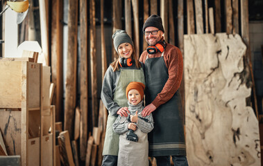 Cheerful parents with kid in craft workshop