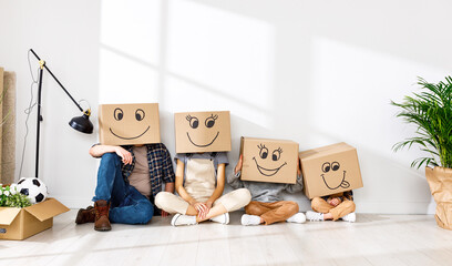 Family in funny carton boxes standing in new flat