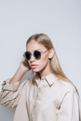 Simple shot of stylish perfect skin model in sunglasses and shirt