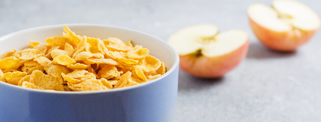 Corn flakes in a blue Cup and Apple slices. Useful Breakfast in the morning. Copy space