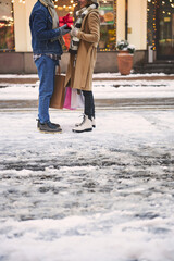 Fototapeta na wymiar Caring man and woman exchanging Christmas presents outdoors