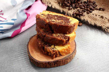 cake, and coffee beans scattered on black wooden table, close up view