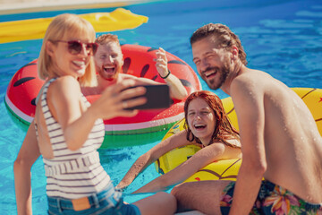 Fototapeta na wymiar Friends taking a selfie at the swimming pool