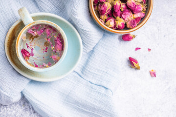 Cup of roses tea with rose buds on light background. Tea with rose.