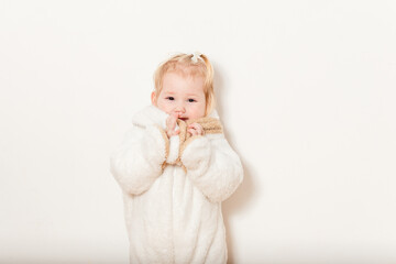 half-year-old European baby girl in fluffy white bunny costume on white background