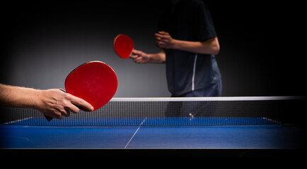 Table tennis ping pong paddles and white ball on blue board