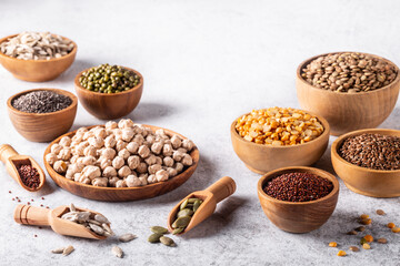 Assortment of beans, seeds, legumes on white concrete background.