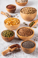 Assortment of beans, seeds, legumes on white concrete background.