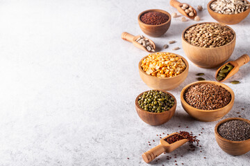 Assortment of beans, seeds, legumes on white concrete background.